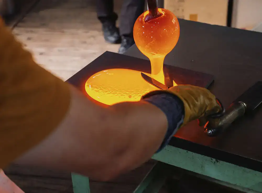 Artisan shaping molten glass